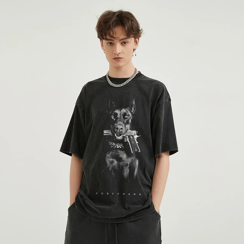Person wearing a black t-shirt with a graphic design on a plain background