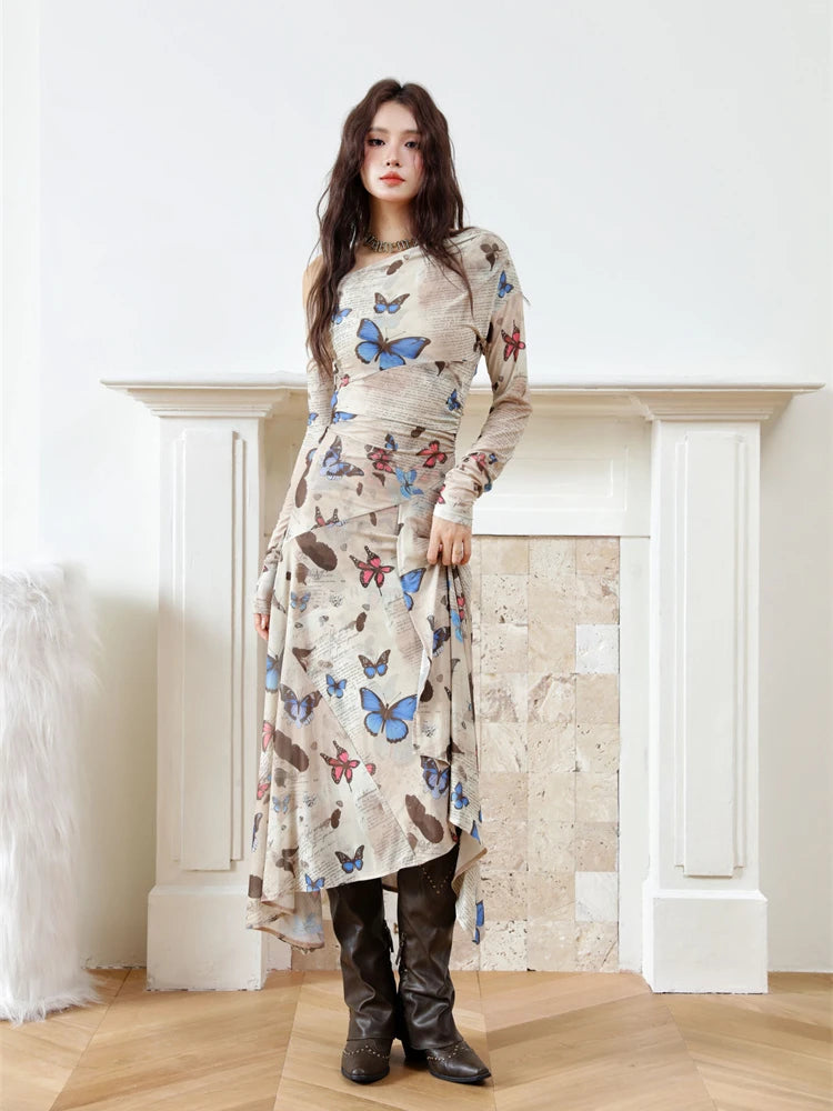 Woman wearing a long dress with butterfly pattern in a room with a fireplace.