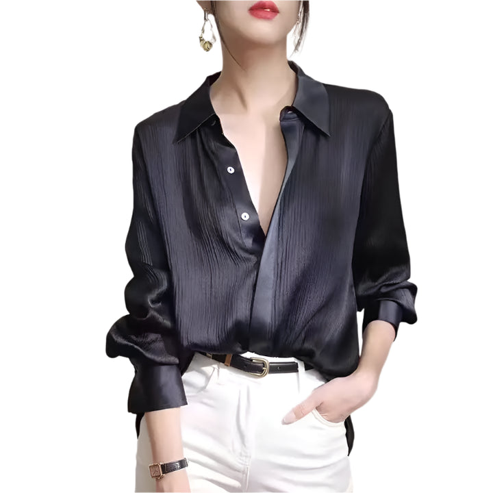 Person wearing a black satin shirt with white pants on a plain background