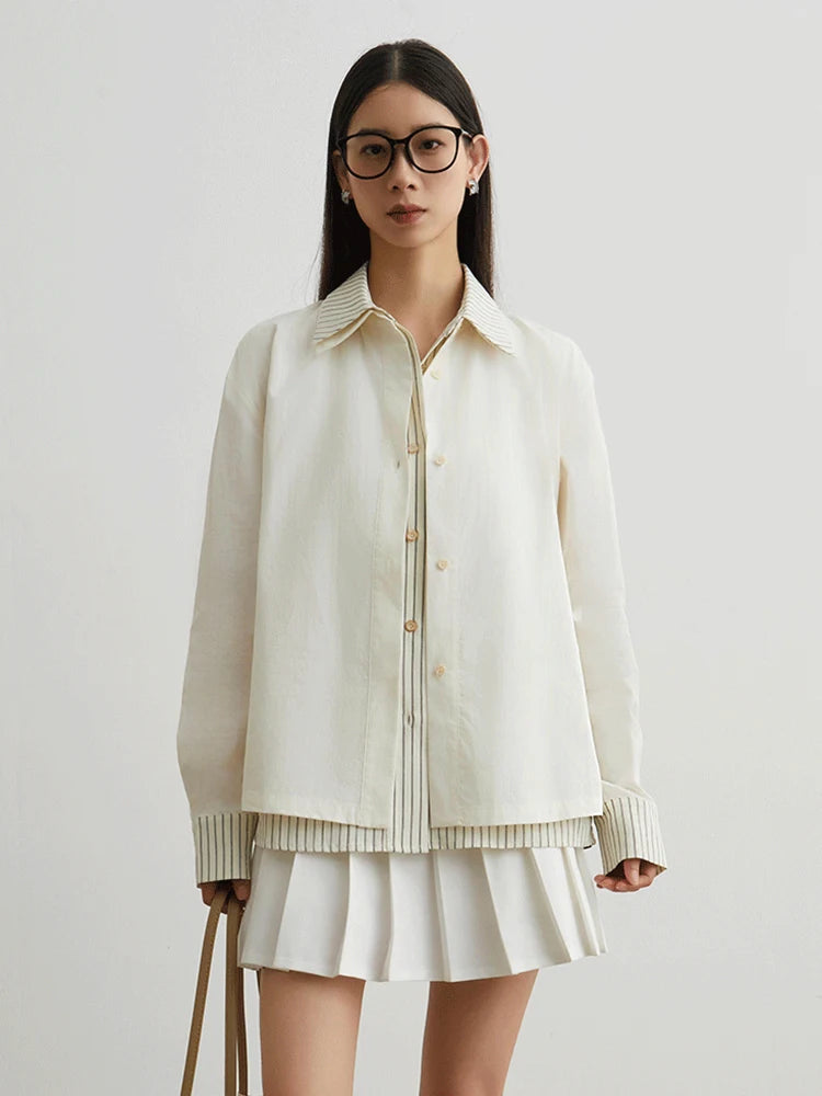 Woman wearing a cream-colored jacket and skirt on a plain background