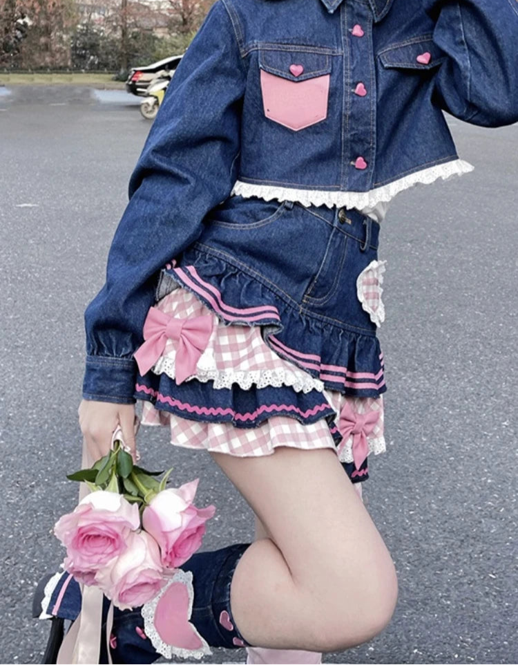 Person wearing a denim outfit with pink accents, holding flowers on a street.