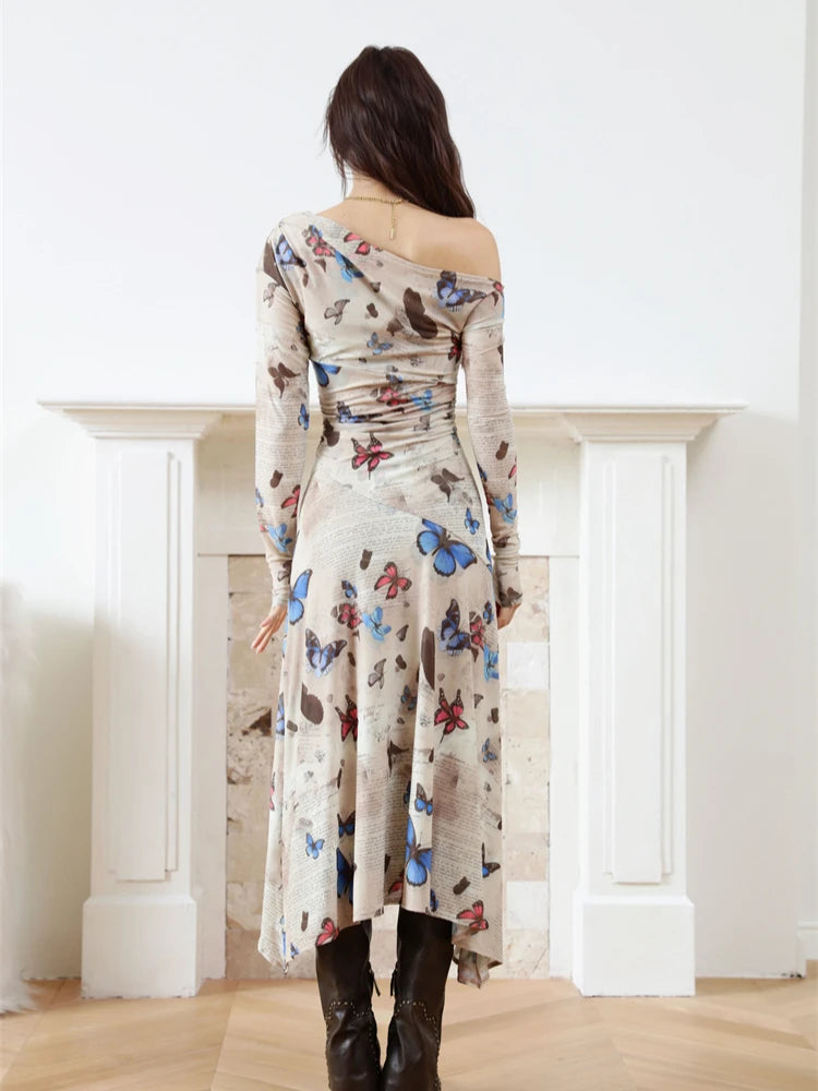 Woman wearing a long-sleeve dress with butterfly pattern in a minimalistic room.