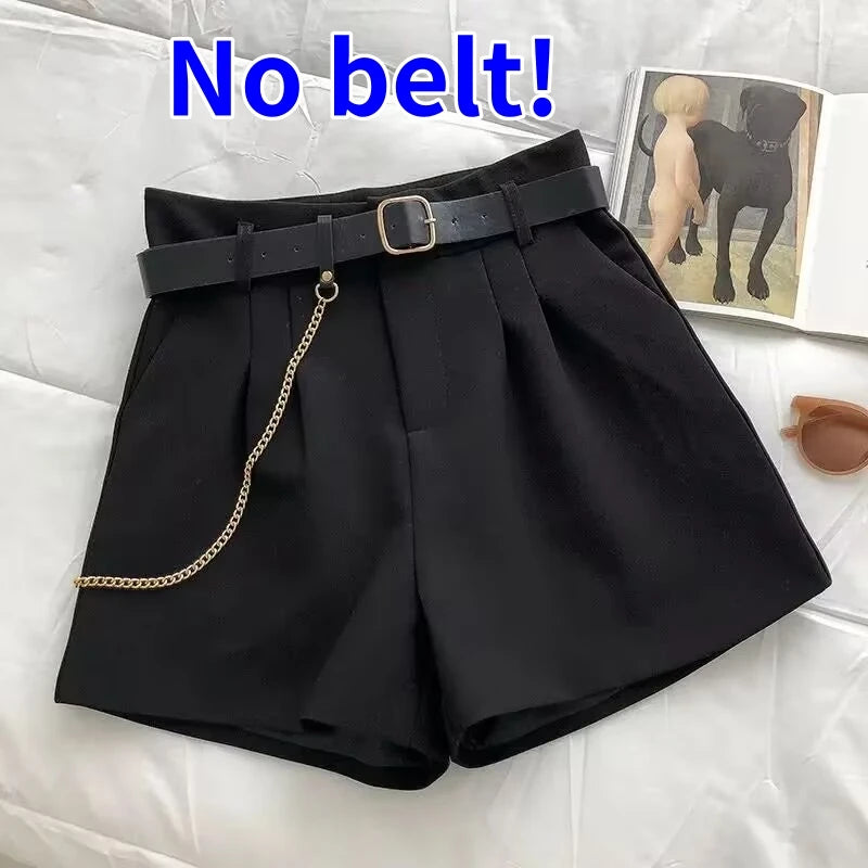 Black shorts with a belt and chain on a white surface