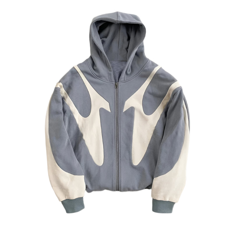 Gray and white hoodie with geometric design on a concrete surface