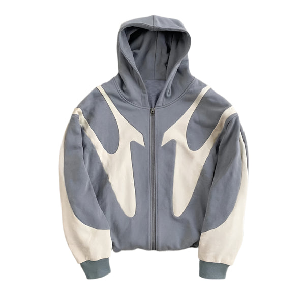 Gray and white hoodie with geometric design on a concrete surface